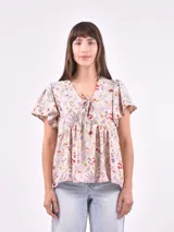 Blusa estampada con cuello en V y mangas cortas con volados.