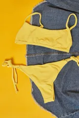 Conjunto de bikini con estampado animal print, compuesto por un corpiño bandeau con breteles finos y una bombacha vedetina con tiras laterales ajustables.