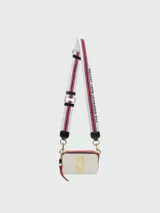 Bandolera Marc Jacobs modelo The Snapshot, de cuero color gris con detalles en beige y herrajes dorados. Presenta correa de tela con el logo de la marca y doble compartimento con cierre.