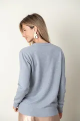 Sweater lila de tejido de punto con detalle de relieve en el frente y cuello redondo.
