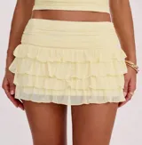Minifalda color amarillo pálido, con cintura elastizada y volados en capas.