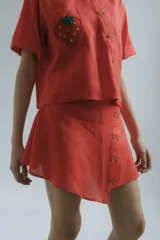 Minifalda roja de lino con botones de madera en el frente.