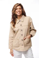 Sobrecamisa de jean color beige, con cuello clásico, cierre frontal con botones y dos bolsillos de parche en el pecho.