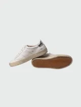 Championes Golden Goose modelo Soul Star, de cuero blanco con detalles en plateado en el talón y logo GGDB en el lateral. Diseño acordonado y suela con efecto envejecido.
