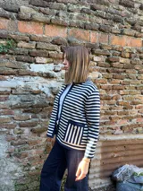Chaqueta tejida en lana merino azul y crudo a rayas horizontales, con cuello redondo y ribete azul en cuello, puños y ruedo.