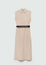 Vestido camisero midi color beige, sin mangas, con cuello camisero, cinturón negro y aberturas laterales.