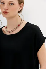 Remera negra de algodón con calce holgado, cuello redondo, largo crop y mangas cortas rebatidas.