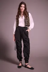 Pantalón jogger negro de nylon con elástico ancho en la cintura, puños elásticos ajustables y lazos laterales para fruncir.