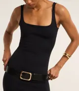 Vestido midi negro de punto roma, con escote cuadrado y corte ajustado. Incluye cinturón ancho de cuero negro con hebilla dorada.