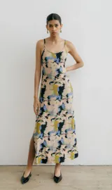 Vestido midi de tirantes finos con estampado floral en tonos azul, negro y naranja. Tiene escote redondo y tajo lateral.