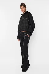 Campera negra oversize con combinación de textil deportivo y sastrero, cierre metálico YKK desmontable, elástico en puños y cintura, vivo a contratono en mangas y cuerpo, forrada al tono.