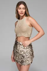 Minifalda dorada con lentejuelas grandes plateadas y negras, de tiro medio y corte ajustado.
