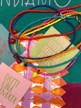 Collar corto de cuentas de colores con dije de limón de vidrio artesanal y cierre bañado en oro de 18k.