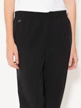 Pantalón babucha negro confeccionado en tejido 4way de alta elasticidad, con cintura elastizada y detalle metálico JCH en el frente.