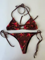 Conjunto de bikini con estampado geométrico en tonos beige, verde y celeste. El top es de triángulo con tirantes finos y la braguita es de corte clásico con tiras laterales ajustables.