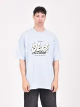 Remera celeste de corte oversized con estampado frontal con la palabra 'Stuck' y una frase en inglés.