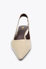 Zapato destalonado color beige con tira trasera elástica ajustable, punta fina y tacón kitten.