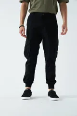 Pantalón cargo negro con puños elásticos, corte regular y bolsillos laterales con solapa.