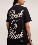 Remera de algodón negra con cuello redondo y manga corta. Presenta un estampado grande en tonos blanco y rojo de la cantante Amy Winehouse, con su firma en letra cursiva roja debajo.