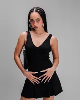 Vestido corto negro con escote en V y falda acampanada. Incluye tirantes finos y corte ajustado en la parte superior.