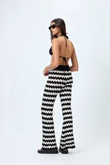 Pantalón tejido con motivo zigzag en tonos beige y blanco, de corte flare y cintura elastizada.