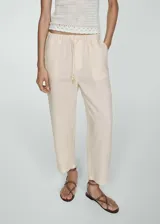 Pantalón negro de lino con diseño crop y jogger, tiro medio, cintura elástica con lazo, dos bolsillos laterales y dos bolsillos de ribete en la parte posterior.