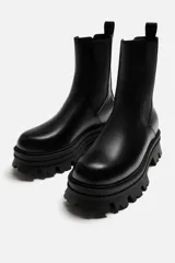 Bota Chelsea de cuero negro con elásticos laterales, tirador trasero y suela track de goma.
