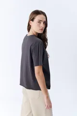 Remera gris oscuro de manga corta con cuello redondo y pinzas laterales que crean un efecto drapeado.