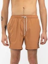 Short de baño color marrón con bordado de enredadera en la pierna izquierda, cintura elástica con cordón regulable, bolsillos laterales y trasero con cierre. Incluye suspensor de malla fina hipoalergénico.