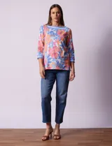Blusa de algodón con estampado de flores en tonos rosa, naranja, azul y blanco. Tiene cuello cuadrado con borde celeste y mangas 3/4 con borde celeste.