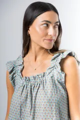 Conjunto de pijama de algodón estampado con flores, compuesto por una musculosa de escote recto con frunces y un short con elástico en la cintura y volados en el ruedo.