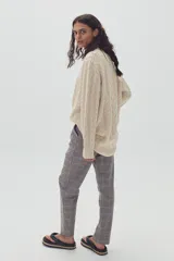 Sweater beige de lana y alpaca con diseño de ochos, cuello redondo y corte oversized.