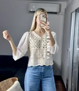 Camisa color crema con detalles de encaje y mangas largas abullonadas de gasa.