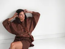 Camisa verde agua de lino, con botones de guampa, más larga atrás que adelante y espalda con tajo en el medio.