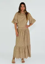 Pollera larga color beige con cintura elastizada y calado con motivos florales.