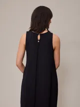 Vestido largo negro sin mangas, de corte recto y cuello redondo.