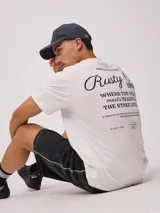 Remera blanca de algodón con estampado en la espalda con el logo de la marca Rusty y texto alusivo al surf. Corte holgado.