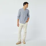 Camisa celeste de lino con cuello mao, manga larga con puños abotonados, cierre frontal con botones y bolsillo de parche en el pecho.
