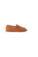 Mocasín de gamuza color terracota con detalle de tachas metálicas.