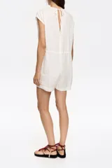 Mono corto de lino color blanco, con escote en pico, manga corta murciélago, corte ajustado en la cintura con lazos y maxilágrima en la espalda.