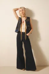 Pantalón jean oxford de tiro medio, color azul oscuro, con recortes laterales y tejido rígido.