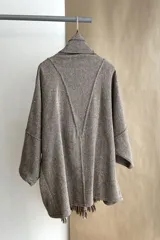 Saco de lana color marrón claro, con mangas amplias, cuello tipo bufanda con flecos y bolsillos laterales. Diseño oversize sin forro.