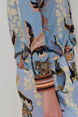 Sweater celeste de cashmere con estampado de tigres y hojas en tonos marrones y beige.