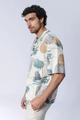 Camisa de manga corta con cuello americano y botones, con estampado abstracto en tonos beige, celeste y negro.