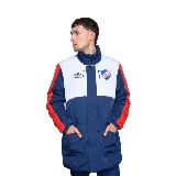 Campera larga acolchada Umbro Heritage del Club Nacional de Football, con diseño en bloques de color azul, blanco y rojo. Presenta cuello alto, cierre frontal con botones a presión, bolsillos laterales y escudo del club bordado en el pecho.