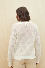 Sweater calado color blanco de punto liviano con diseño geométrico, silueta relajada y terminación en rib en cuello, puños y ruedo.