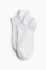 Pack de siete pares de medias invisibles blancas de algodón con borde elástico.