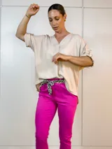 Blusa beige de viscosa con escote en V y mangas cortas con botón.