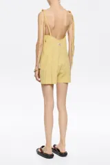 Mono corto amarillo a rayas verticales, con breteles finos con nudo y corte holgado.