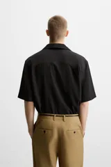 Camisa de hombre relaxed fit con cuello bowling y manga corta, confeccionada en tejido fluido con mezcla de viscosa a rayas verticales en tonos verde y blanco.